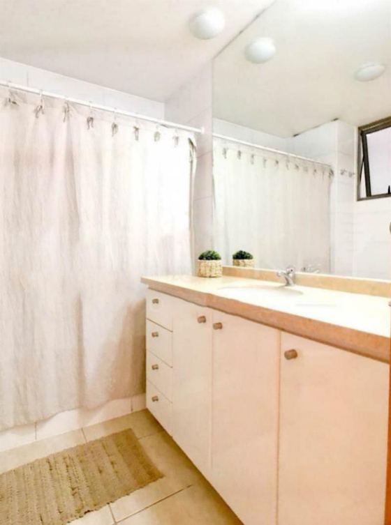 Baño principal con mueble de lavamanos y espejo.