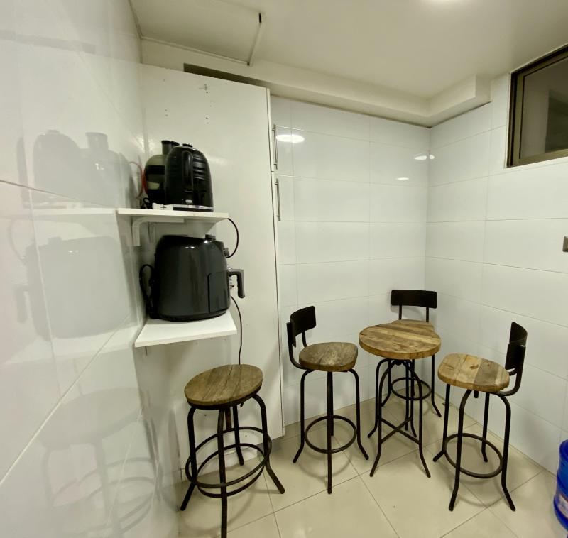 Comedor de diario con barra y cuatro piso altos junto a la cocina.
