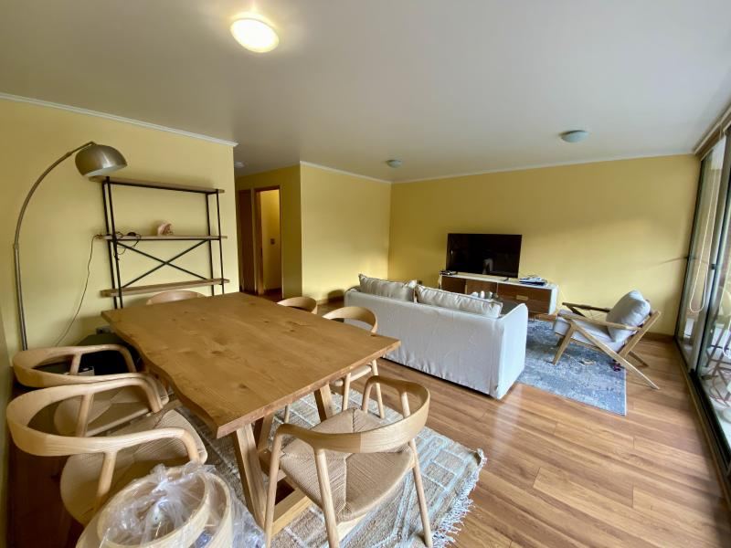 Comedor de madera para seis personas junto al ventanal de la terraza.