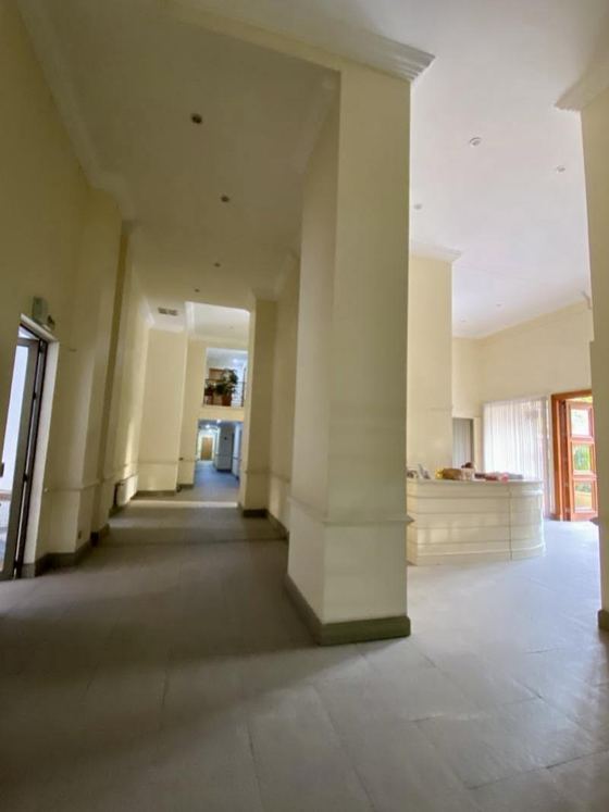 Hall de acceso del edificio con columnas y conserjería.