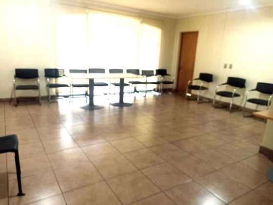 Sala de usos múltiples con sillas dispuestas para una reunión.